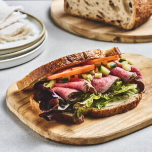 Sandwich på surdeigsbrød med hjemmelaget roastbiff, agurk og tomat